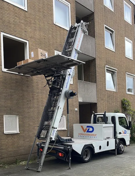 Liftwagen van Verhuisbedrijf Draagkracht met uitgeschoven ladderlift bij een galerijflat