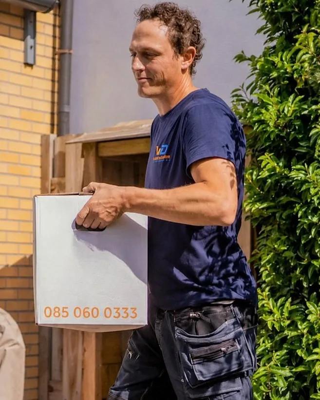 Verhuizer van Verhuisbedrijf Draagkracht draagt een verhuisdoos naar de wagen