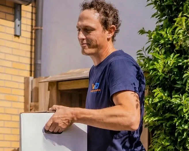 Verhuizer van Verhuisbedrijf Draagkracht draagt een ingepakte doos