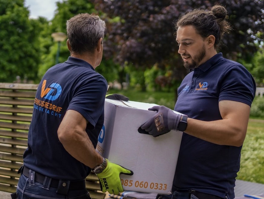 Verhuizers van Verhuisbedrijf Draagkracht dragen een doos